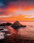 Aerial sunset photograph of Sugarloaf Rock, South West Western Australia, with deep orange and pink sky reflecting on the ocean.